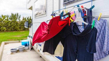 Outdoor laundry drying on a clothesline attached to a campervan.