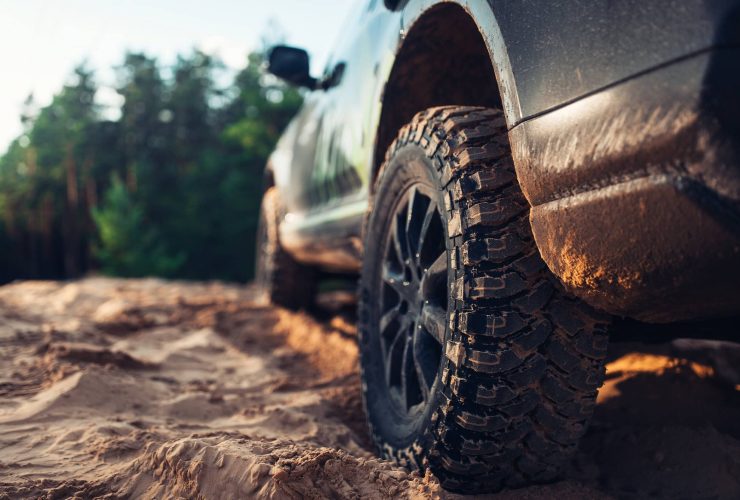 Off-road vehicle driving on rugged dirt trail in natural outdoor setting.