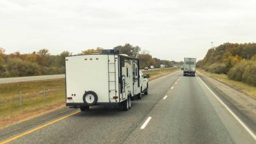 Travel trailer hitched to vehicle on Australian highway.