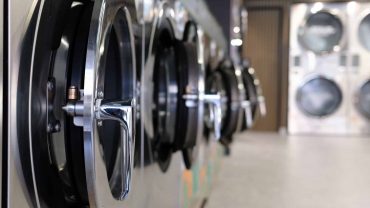Washing machines in a laundromat setting, ready for laundry service.