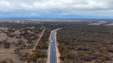 Road trip along a remote Australian highway through bushland.