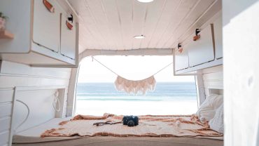 Cozy tiny home bedroom with a stunning ocean view, perfect for beach lovers and minimalist living en.