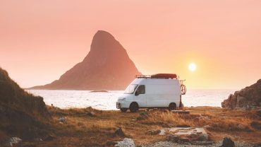 Camping van at sunrise near Mount Cook, New Zealand, with scenic coastal views.
