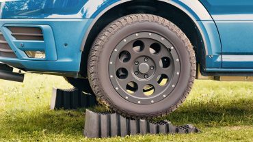 Off-road vehicle with large tires on grass, demonstrating outdoor adventure gear.