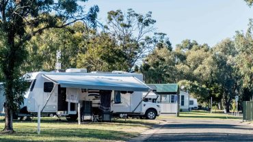 Camping with RVs and caravans in a scenic park setting.