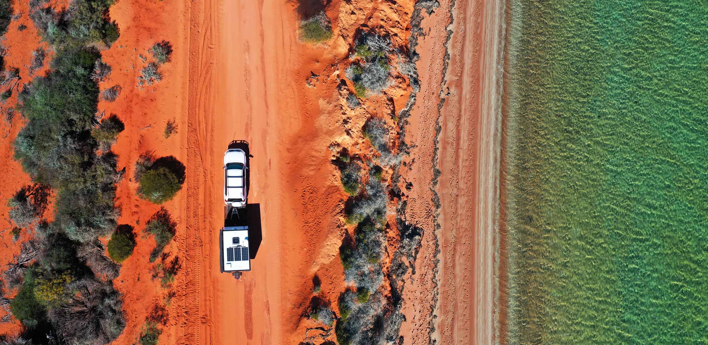 Turquoise waters of Western Australia's Coral Coast with a caravan parked nearby