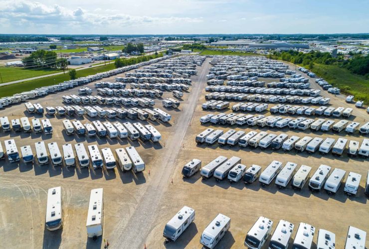 Large RV storage lot with numerous parked caravans and motorhomes.